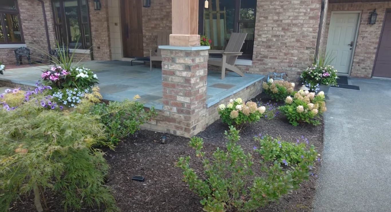 Professionally landscaped patio with brick pillars and flowering garden beds in El Centro, CA